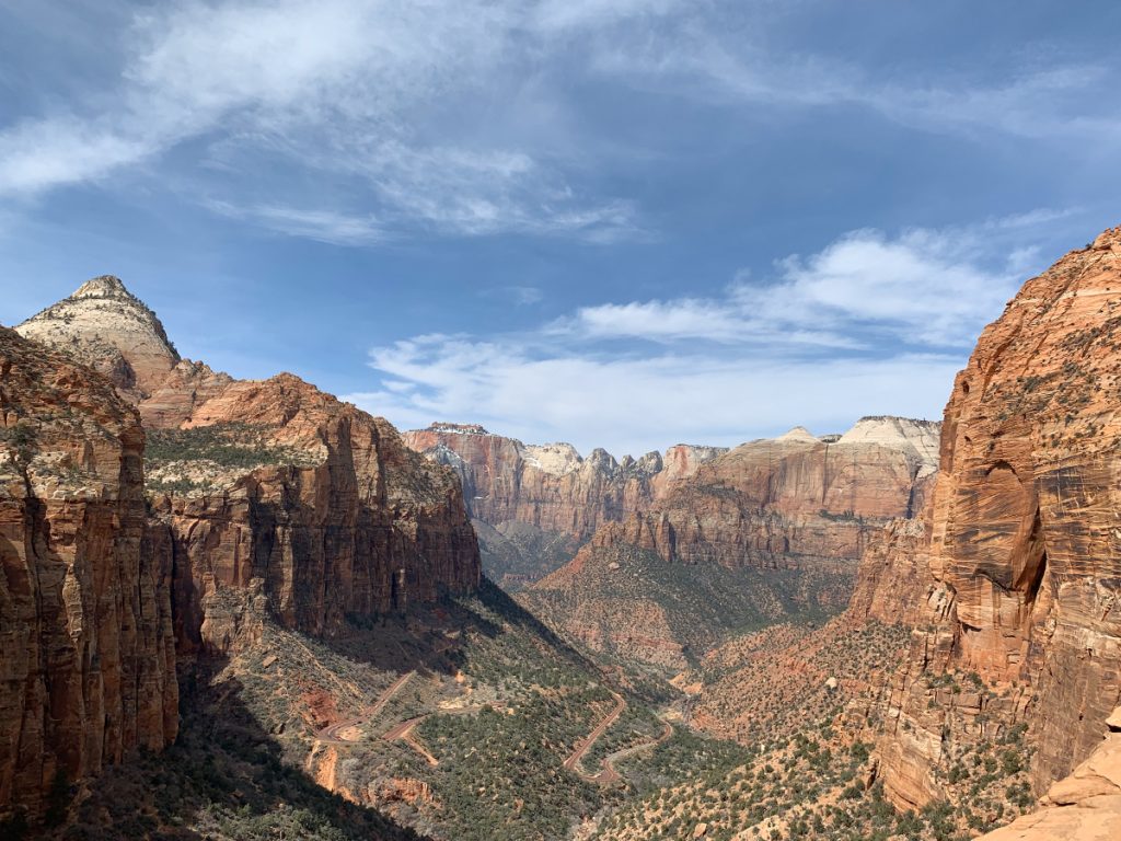 Panoramic view of red rock cliffs and canyons from Canyon Overlook Trail, one of the best hikes in Zion National Park.